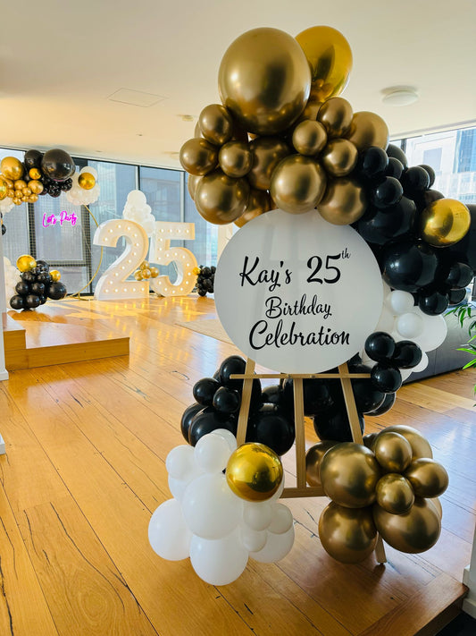 Guirnalda de globos en blanco, negro y dorado + caballete y neón